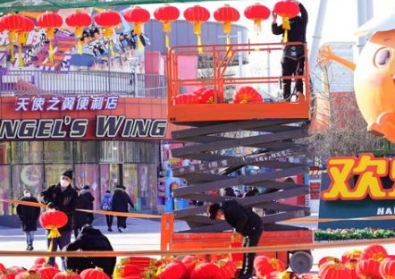 北京歡樂谷工作人員用升降平臺車懸掛新年燈籠